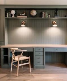 a chair and desk in a room with built - in bookshelves