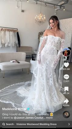 a woman in a white wedding dress standing next to a bed