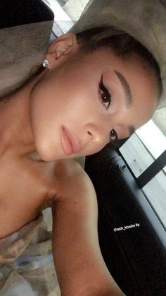 a woman wearing a hat and posing for the camera