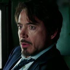 a man in a suit and tie looking at the camera with an angry look on his face