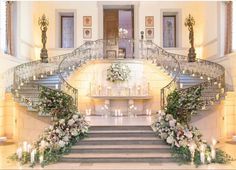 an elegant staircase decorated with flowers and candles