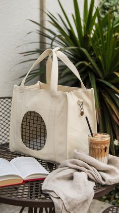 an open book sitting on top of a table next to a bag and a cup