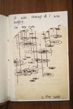 an open book with drawings on it and writing in the pages that says, it was raining & i was happy to my own