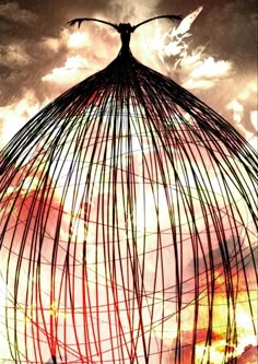 the silhouette of a person standing on top of a birdcage in front of a cloudy sky