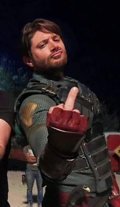 two men dressed in costume standing next to each other and pointing at something with their fingers