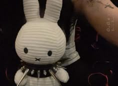 a close up of a stuffed animal near a person's arm with tattoos on it