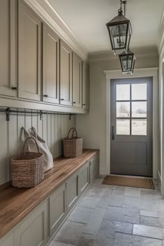 an entryway with two baskets on the bench and a lantern hanging from the ceiling