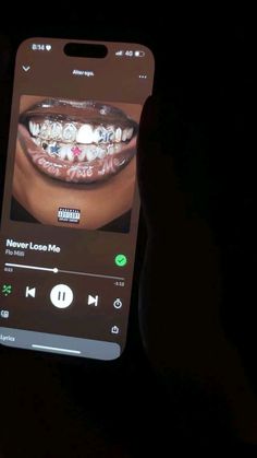 someone holding up a cell phone with an image of a woman's teeth on it