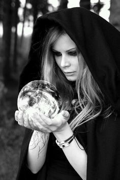 a woman with red hair wearing a black hoodie and holding her hands out in the air