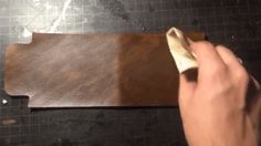 a person using a knife to cut leather