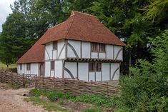 an old house with a wooden fence around it's perimeter and trees in the background