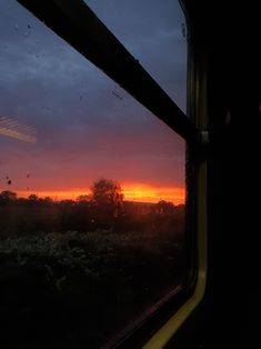 the sun is setting in the distance as seen from a train window