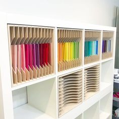 the shelves are filled with different colored papers