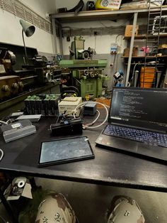 a laptop computer sitting on top of a table next to other electronics and gadgets