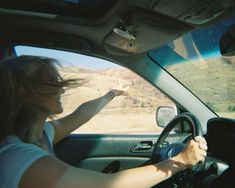 a woman driving a car in the desert