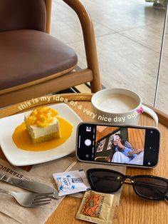 a cell phone sitting on top of a wooden table next to a plate with food