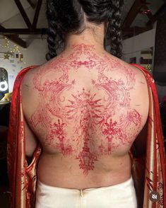the back of a woman's body with red ink on it