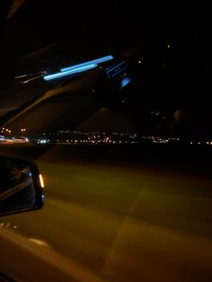 the view from an airplane window at night with city lights in the background