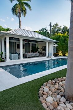 a house with a swimming pool in the middle of it and a palm tree next to it