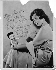 an old black and white photo of a woman holding a doll with writing on it