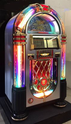 an old fashioned jukebox with colorful lights on it's front and sides