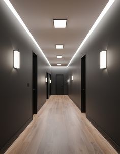 an empty hallway with lights on the ceiling and wood flooring in front of it