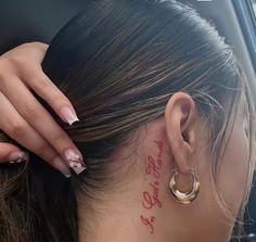 a woman with red writing on her face and behind her ear is sitting in a car
