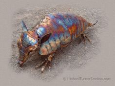 a colorful insect laying on the ground in sand with it's head turned to the side
