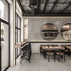the interior of a restaurant with round mirrors on the wall and wooden tables in front of them