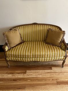 a striped couch sitting on top of a hard wood floor