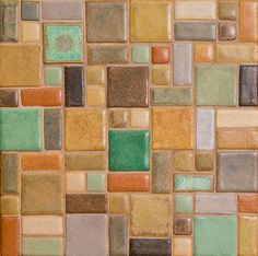 a close up view of a tile wall with many different colors and shapes on it