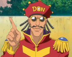 a man with dreadlocks pointing to the side while wearing a red and yellow uniform