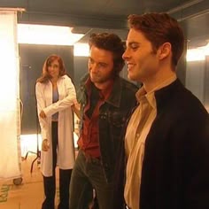 two men and a woman standing in an office