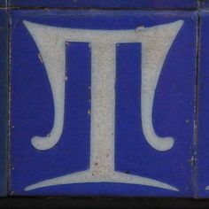 a blue and white tile with the letter t on it