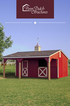 a red horse barns sits in a pasture on a sunny day