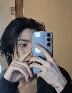 a person taking a selfie in front of a mirror with their cell phone up to their face