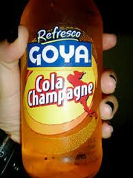 a person holding a bottle of goya cola champagne in their left hand, with the label on it