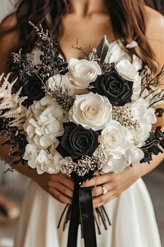 a woman holding a bouquet of white and black flowers