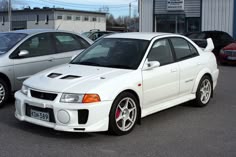 a white car parked in front of two other cars