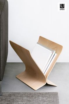 a wooden table with a magazine holder on it's side next to a couch