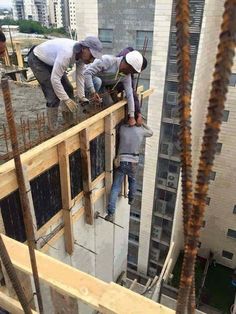three men working on the roof of a building