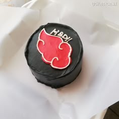 a black and red frosted cake with the word boy on it's side