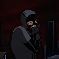 batman in the dark knight animated series standing with his hand on his face and looking down