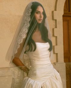a woman wearing a wedding dress and veil