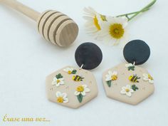 the earrings are decorated with flowers and beehive designs, along with a honey comb