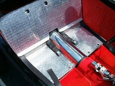 the inside of a red car with its door open and handlebars still in place