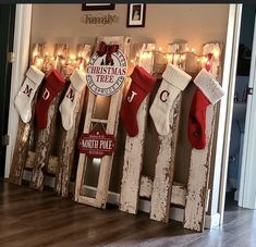 christmas stockings hung on wooden boards in front of a wall decorated with lights and decorations