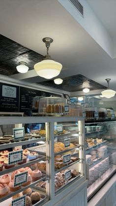a bakery filled with lots of different types of cakes and pastries on display behind glass