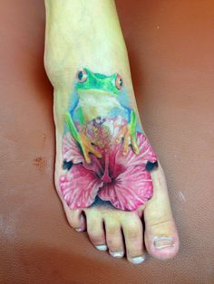 a person with a tattoo on their foot has a flower and a frog on it