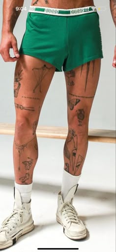 a man in green shorts with tattoos on his legs